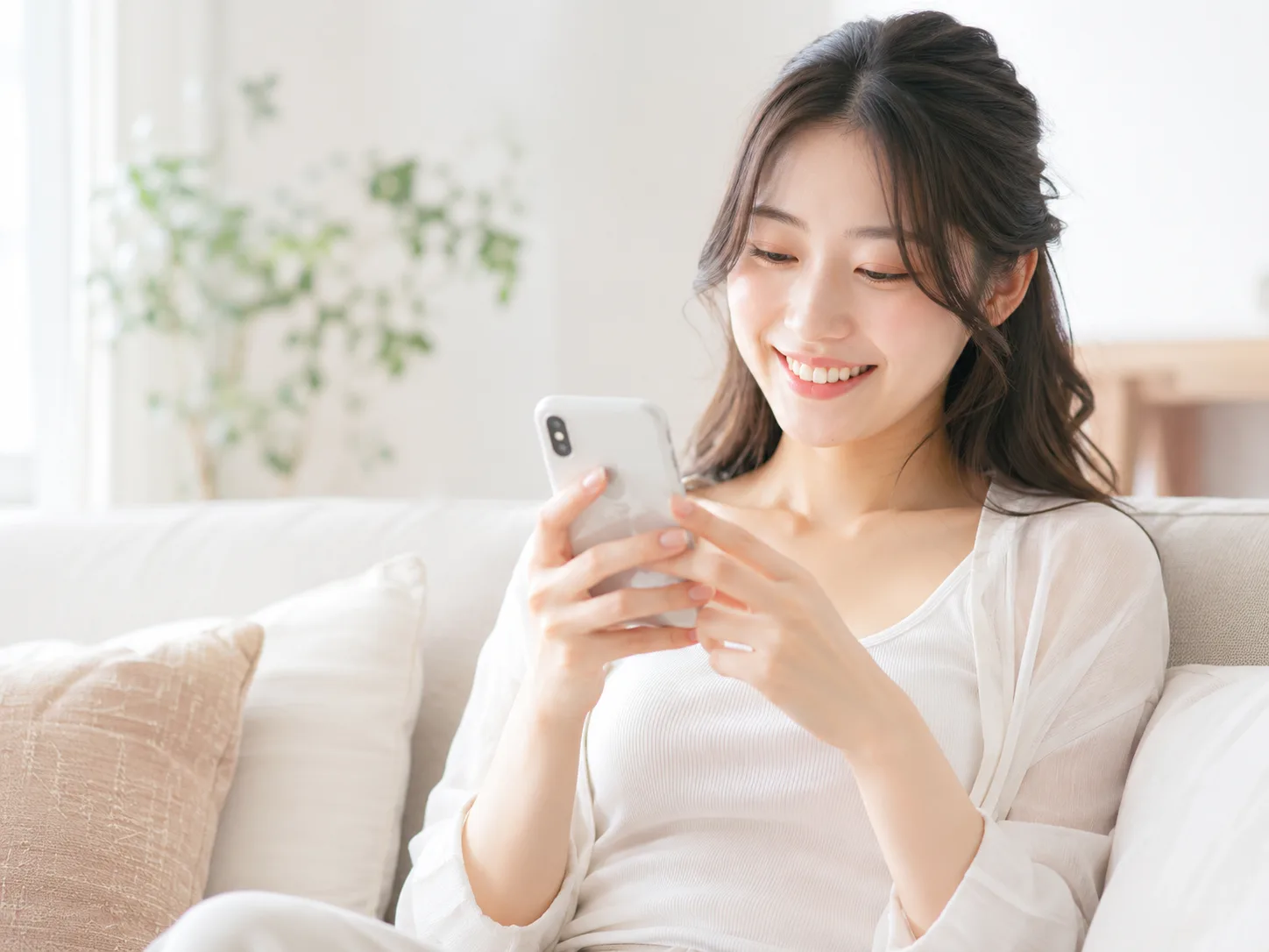 自宅のソファでリラックスして働く女性